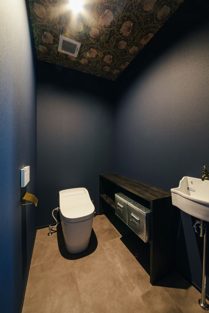 車椅子のままでも入れる広いトイレ。天井にウィリアム・モリスのデザインクロスを貼ってニュアンスを出してます。造作の収納棚、レトロチックな手洗いコーナーにもこだわりました。